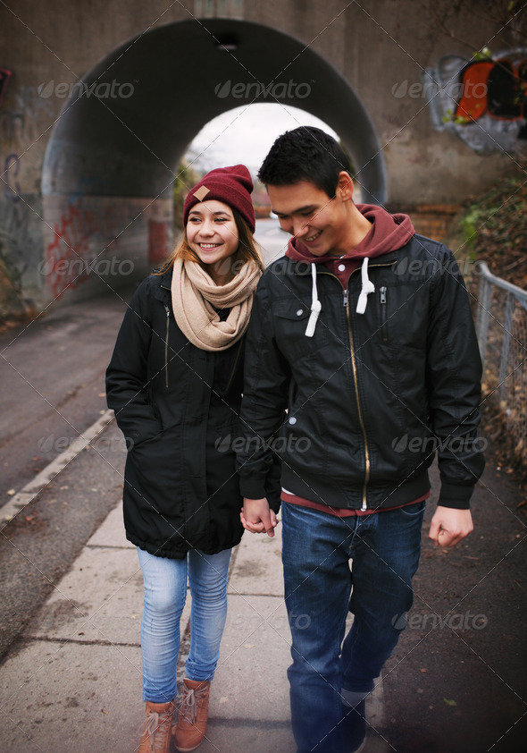 Loving young couple walking on a street - Stock Photo - Images