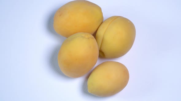 Close Up. Rotation of Yellow Apricots on White Background