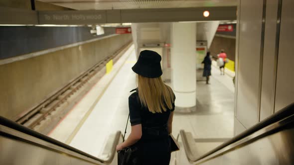 Beautiful Trendy Girl Blogger Going Down Escalator