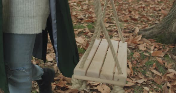 Detail of Young Woman Legs Walking To Swing and Sit Down. Beautiful Blonde Woman Swinging and Having alt