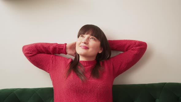 Caucasian Woman Relaxing and Stretching on the Sofa While Taking a Break alt