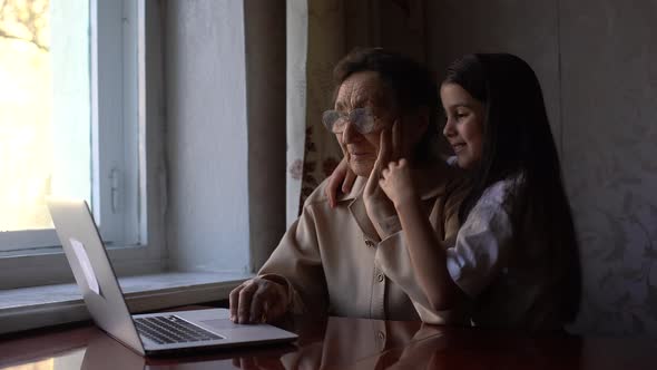 Great Grandmother and Granddaughter Wave To Family on Computer alt