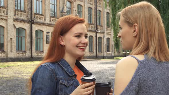 Two Girls Having a Talk and Drinking Coffee