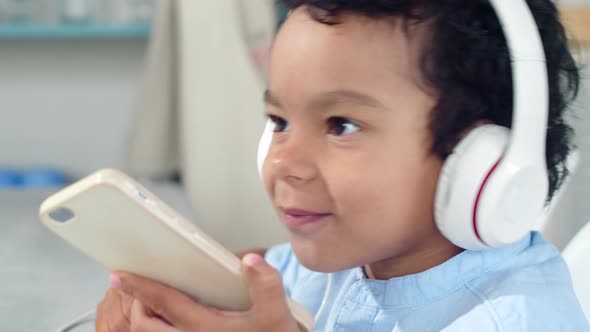 Little African Boy Enjoying Music on Mobile Phone