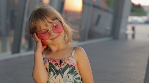Tourist Kid Girl Wearing Stylish Sunglasses Use Phone. Child Using Smartphone for Call Talk. Tourism alt