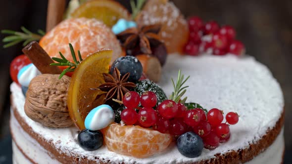 Festive New Years Cake Decorated with All Sorts of Fruits Spinning on a Rotating Stand alt