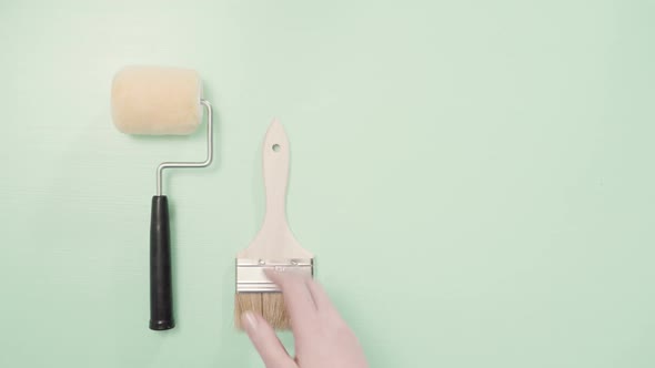 Paint brush and roller for house painting project. alt