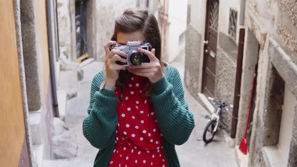 Pretty Woman Tourist Is Taking Photo on Vintage Camera alt