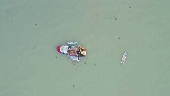 Aerial top view, circling around a fishing boat alt