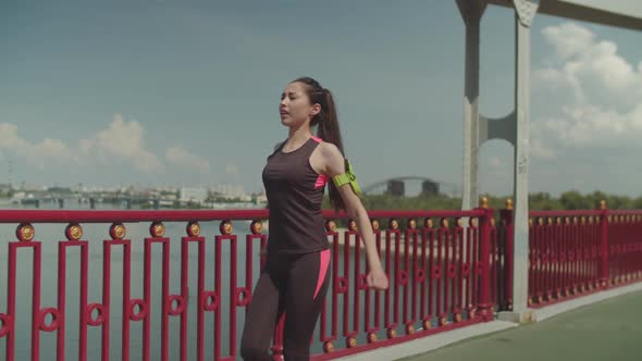 Sporty Fit Woman Warming Up During Walk Outdoors alt
