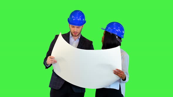 Young Female Architect and Expert Engineer Analyzing Blueprint Together Work Team Wearing Hardhats alt