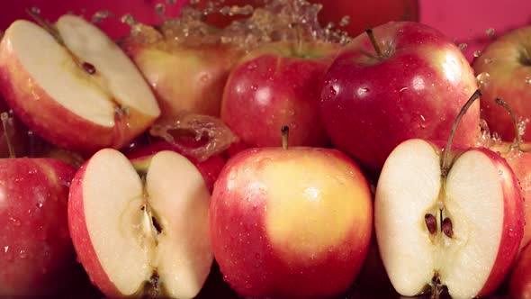 Slow Motion Shot of Red Apple Juice Splashing Through Apple Slices alt