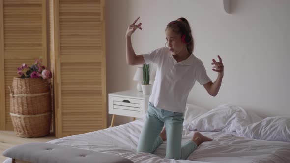 Funny Cute Little Girl Putting on Headphones and Trying To Dance and Falling on the Bed alt