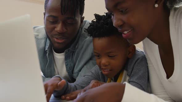 Family using laptop together at home alt
