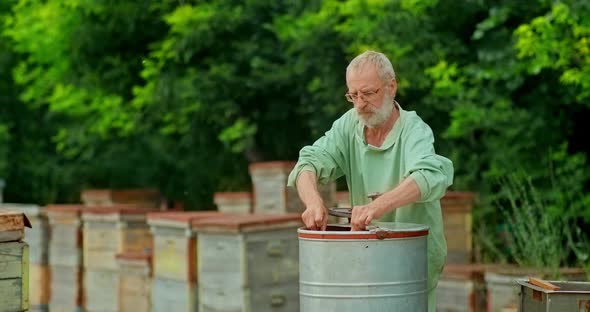 Beekeeper Inserts the Honeycomb Frame Into the Honey Extractor. Beekeeper Turns the Handle of the alt