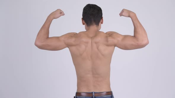 Rear View of Young Muscular Shirtless Man Flexing Muscles alt