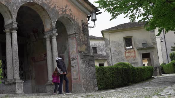 A mother and her little daughter carrying a teddy bear visiting the sacred mountain of Varallo chris alt