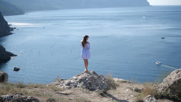 The Girl on the Edge of a Cliff Near the Sea