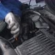 Hand of worker is woman holding oil dipstick checking oil level in engine of car in the garage. - VideoHive Item for Sale