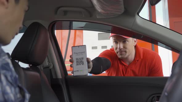 A customer, people, paying gas bill by scanning QR code, online payment at gasoline petrol station alt