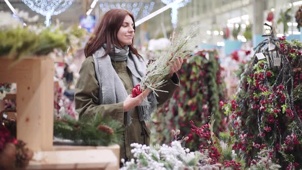 A Young Beautiful Woman Walks Around the Store and Selects Christmas Decorations and Decorations to alt