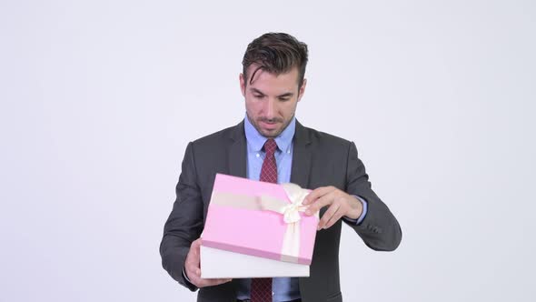 Young Happy Hispanic Businessman Opening Gift Box alt
