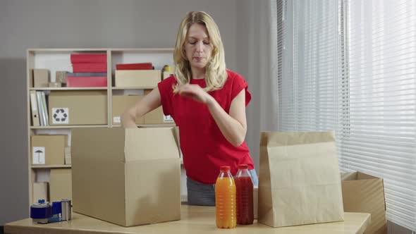 Young Female Online Store Owner Warehouse Worker Merchant Seller Packing Shipping Package Preparing alt