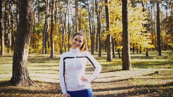 Young Female Smiling and Flirting Listening to Music Through Earphones Connected to Cellphone Posing alt