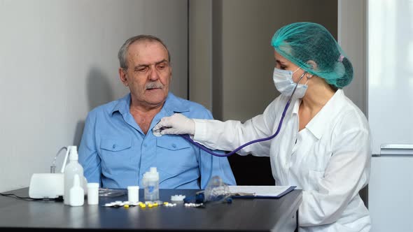 Doctor Checks Lungs of Senior Man By Stethoscope alt