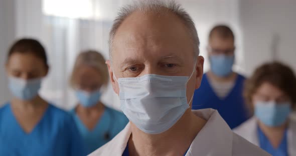 Team of Professional Male and Female Doctors Wearing Protective Mask in Hospital alt