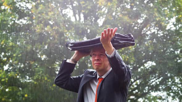 Businessman Sheltering Underneath his Bag in the Rain