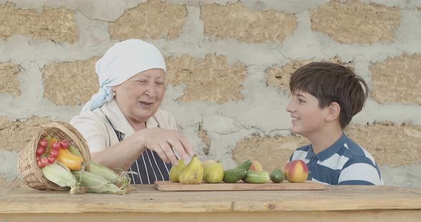 A Teenager and His Grandmother are Resting Against the Background of the Harvested Crop From the alt