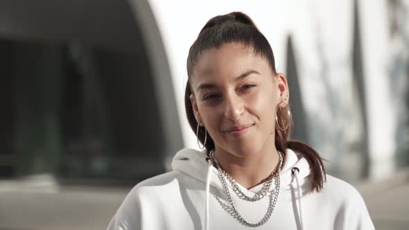 Portrait of Happy Young Hispanic Woman with Casual Sportswear Smiling and Looking at Camera with alt