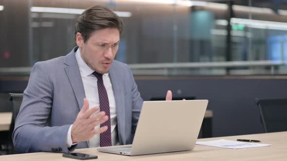 Middle Aged Businessman having Loss on Laptop in Office  alt