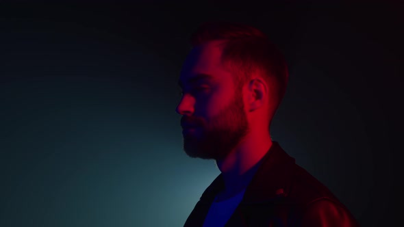 Portrait of Caucasian Man with Beard in Leather Jacket Illuminated Neon Light alt