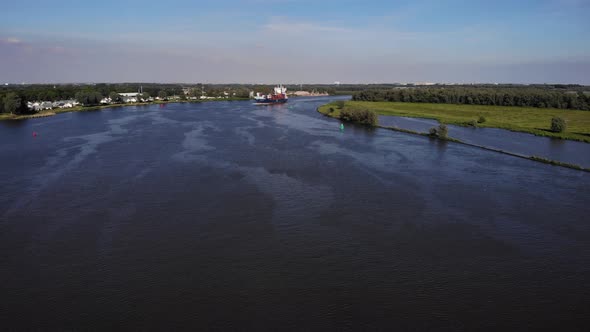 Rippling River Water With Container Ship Cruising On A Sunny Day. wide aerial shot alt