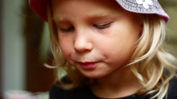 Girl Preschooler in a Hat Eats a Pie