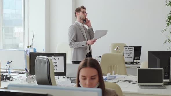 Businessman Talking on Phone Call in Office during Covid-19 Pandemic alt