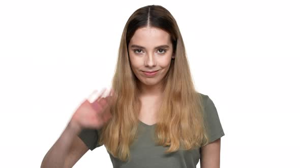 Portrait of Hospitable Woman with Dyed Auburn Hair Smiling on Camera and Greeting with Waving Hand alt