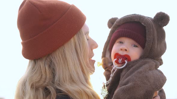 mom kisses baby in the sun rays