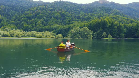 Young Couple are Sailing on a Old Wooden Boat in Biogradsko Lake in Montenegro alt