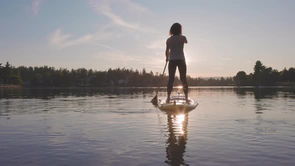 Adventurous Caucasian Adult Woman Paddling on a Stand Up Paddle Board alt
