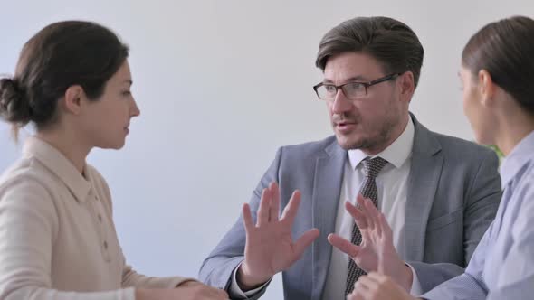 Serious Middle Aged Businessman Talking to Mixed Race Businesswoman alt