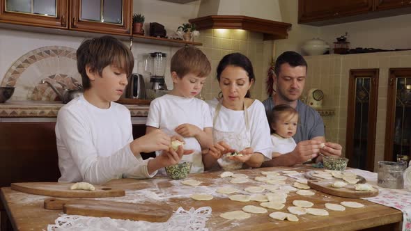 Children with Parents is Preparing Dumplings in Domestic Kitchen