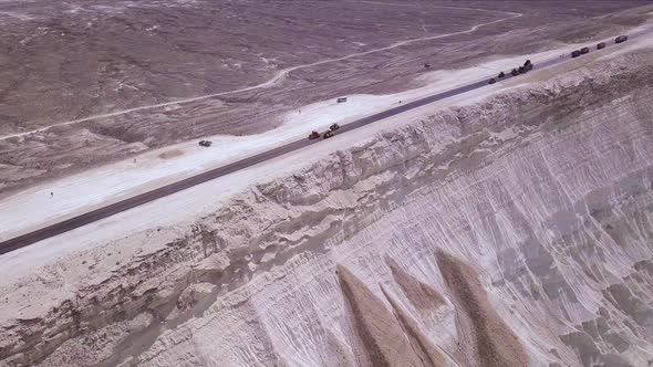 Big quarry with road next to and cars on