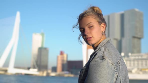 Slowmotion Side View of Tender Stylish Young Blond Woman with Blue Eyes Standing Near Bridge and alt