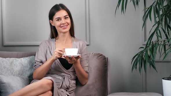 Woman Relaxing at Home During Morning Holding Cup of Coffee alt