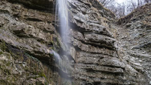 Panoramic view of a small waterfall on a large rock alt