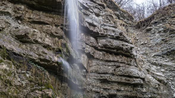 Panoramic view of a small waterfall on a large rock