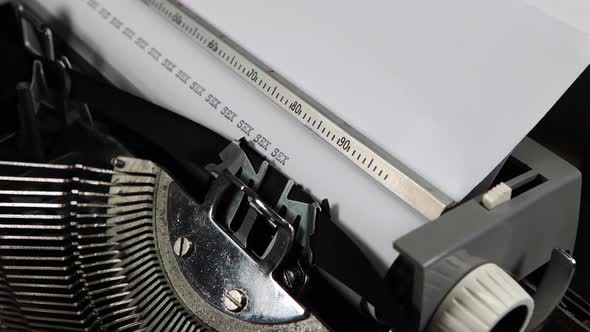 An old fashioned vintage typewriter spelling out the word sex multiple times alt